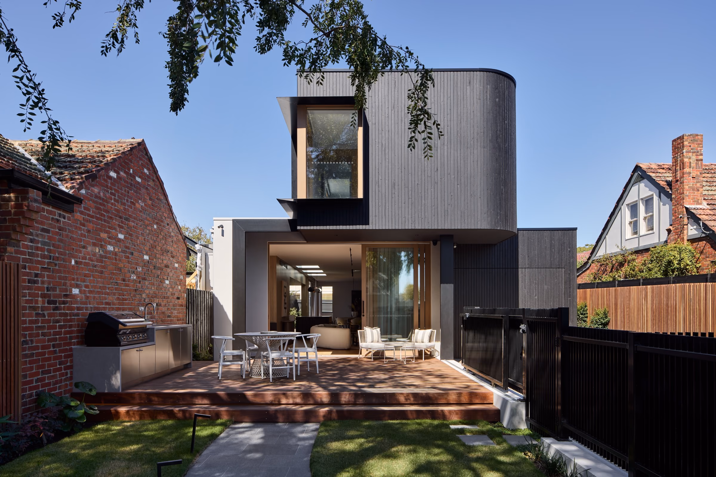 Ravenwood House exterior with curved timber facade and outdoor deck